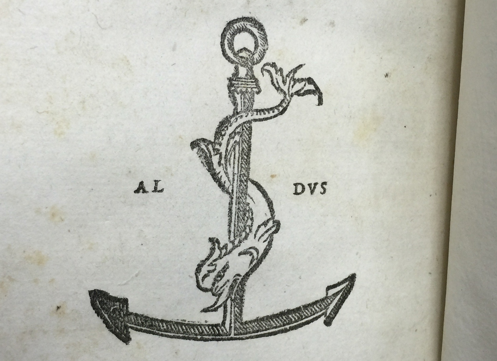 Device of Aldus Manutius of Venice from the book Letters by Plini the elder: A dolphin wrapping around an anchor.